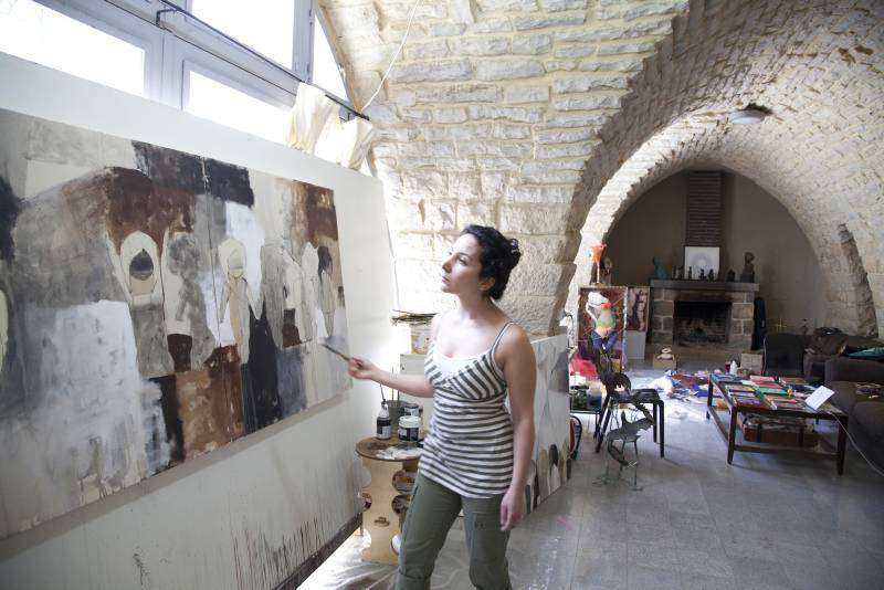 After experiencing war and displacement, Reem no longer uses bright colours in her work. Here she paints figures of children using only white, brown, black and grey, which she says reflects her feelings of despair and hopelessness. The converted coach house is an ideal workplace with its high vaulted ceilings, space and plenty of light.  