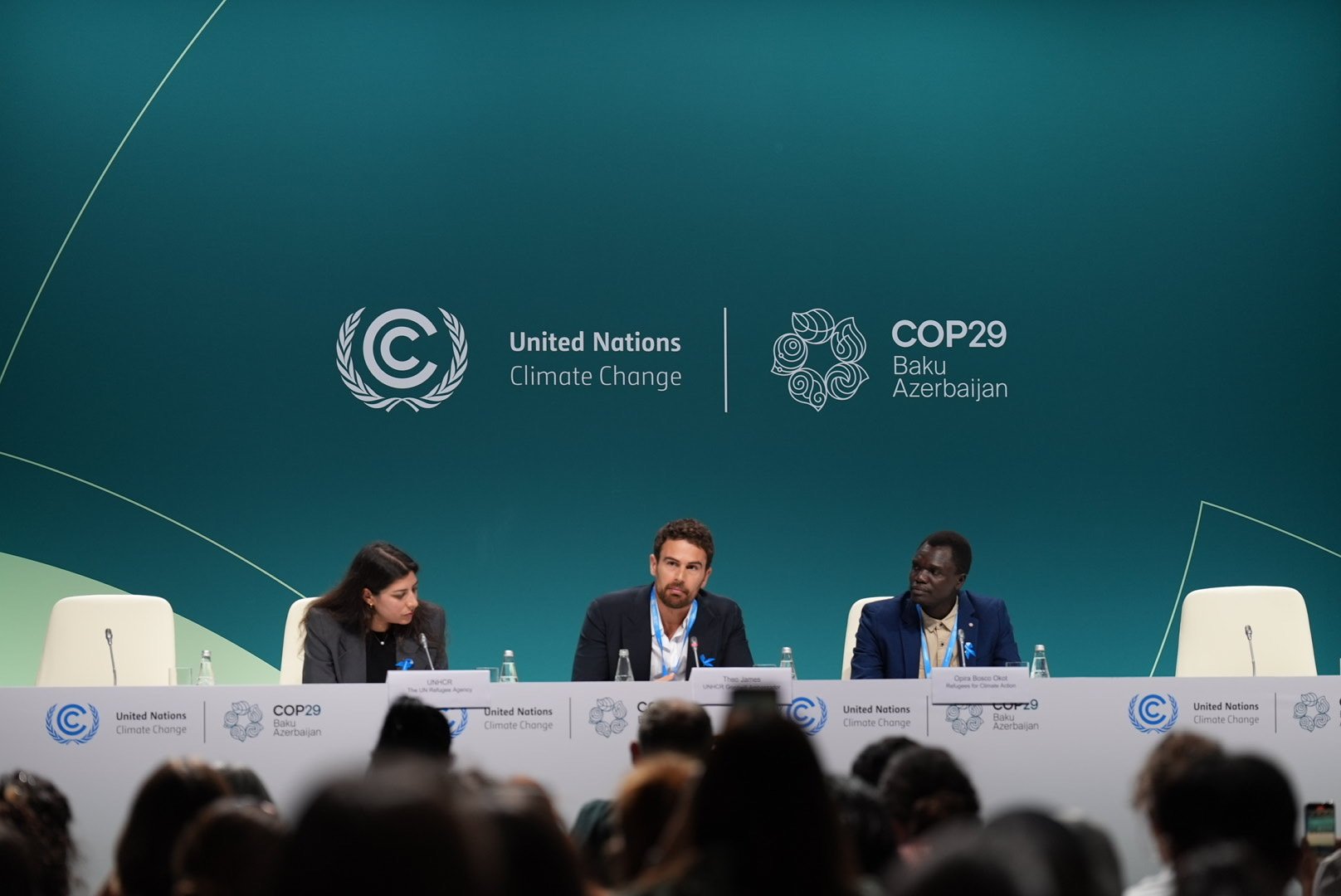 A woman and two men address a session at COP29.