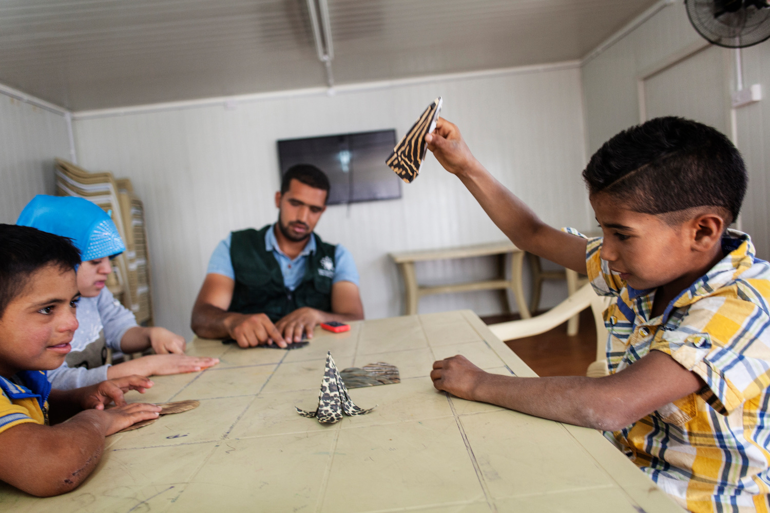 Jordan. 25-year-old Fadi Al Wali teaches origami to special needs children and other children at Za'atari refugee camp.