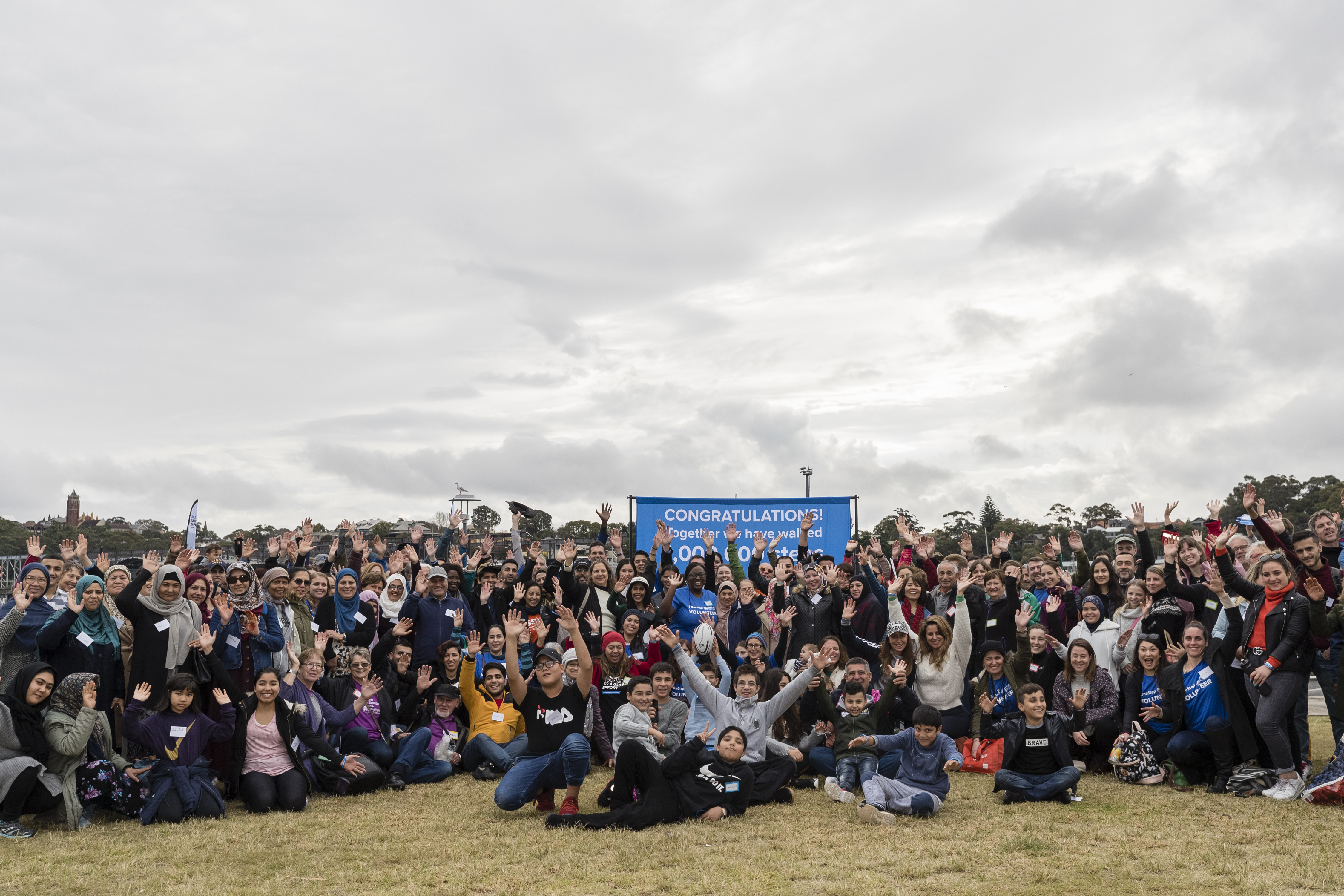 A large crowd gathers in Pirrama Park as Australians walk together with their neighbours from refugee backgrounds around Sydney harbour to celebrate World Refugee Day.