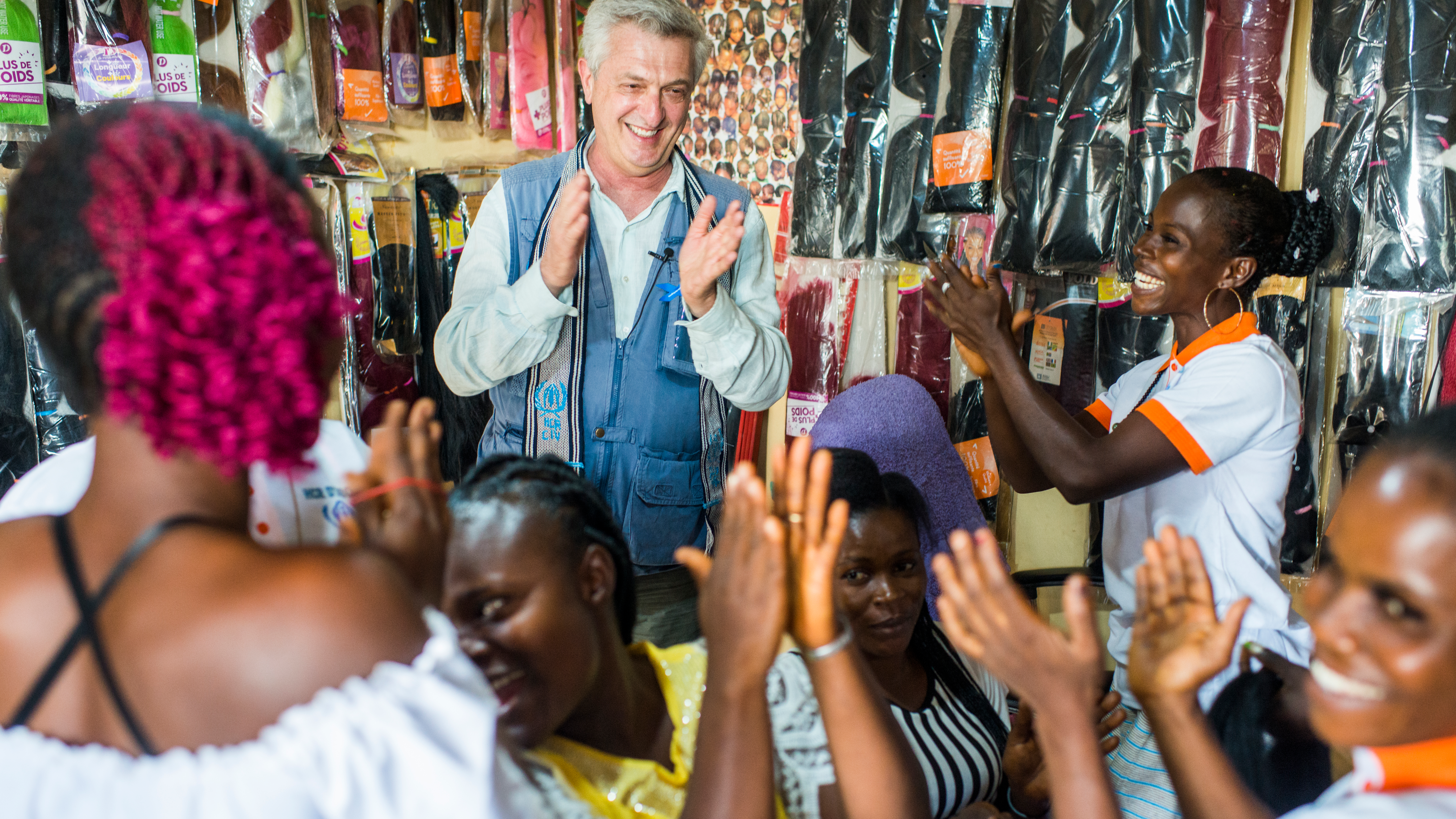 VN Hoge Commissaris voor de Vluchtelingen, Filippo Grandi, ontmoet teruggekeerde Ivoriaanse vluchtelinge Elodie Guei Sahe in haar kapsalon “Seatizi”, wat vrede betekent, dat ze mede dankzij steun van UNHCR kon openen. © UNHCR/Colin Delfosse