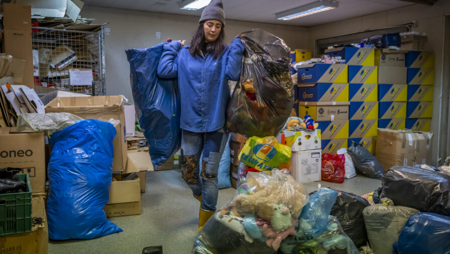 Agnieszka trie les dons de nourriture, de vêtements et d’autres produits essentiels destinés aux personnes qui se rendent au centre. © HCR/Anna Liminowicz
