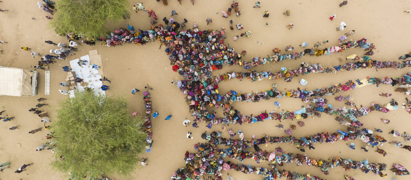 'Een luchtfoto van hulpgoederen die worden uitgedeeld aan zonet aangekomen Soedanese vluchtelingen in Madjigilta in Tsjaad. © UNHCR/Colin Delfosse