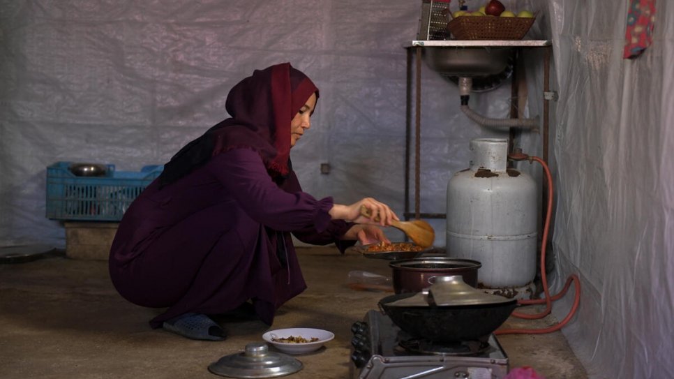 Majida prepares a meal for her children after they return home from school_UNHCR_Haidar Darwish