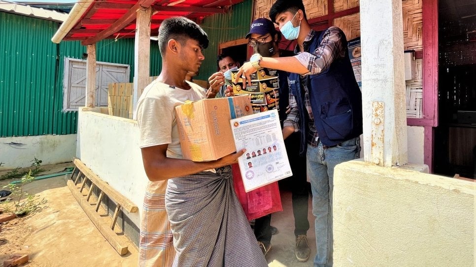 Refugee volunteers deliver aid to families affected by the fire in the Kutupalong-Balukhali camps, Bangladesh. © UNHCR/Amos Halder