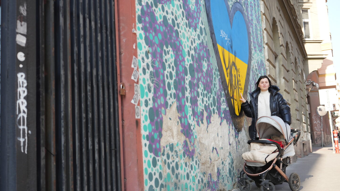 Hungary. Ukrainian refugee Liubov (42) in front of a graffiti heart featuring the colors of the Ukrainian national flag in Budapest's 7th district on February 14, 2023.