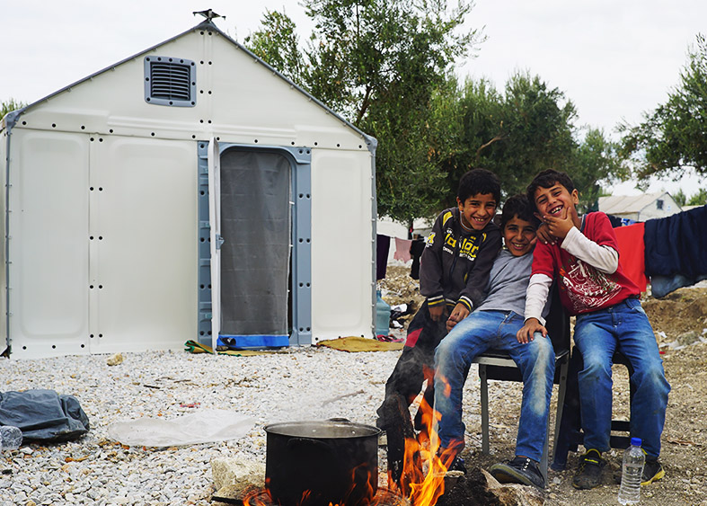 Refugee boys in Lesbos, Greece outside of a Better Shelter Unit.