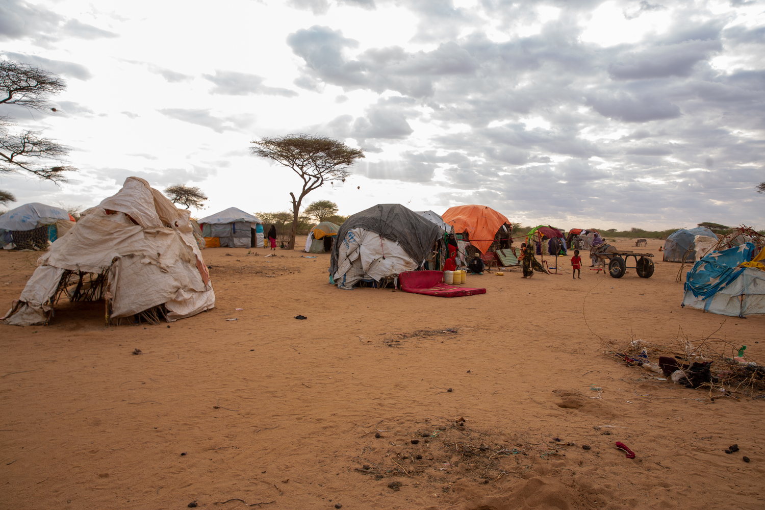 Makeshift shelters in an arid landscape.