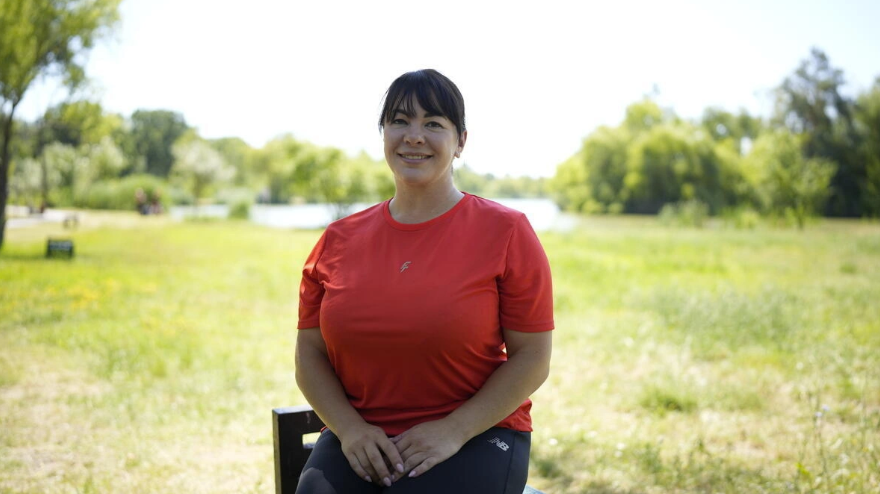 Olena Prysyazhniuk, refugiată ucraineană, stă lângă un lac unde practică în mod regulat paddleboard în capitala Moldovei, Chișinău.© UNHCR/ProImagine