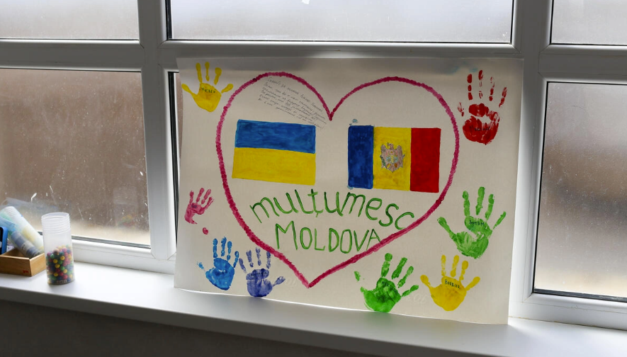 Desenul unui copil pe care scrie „Mulțumesc, Moldova” este agățat la fereastra unei fabrici din Chișinău, transformată în spațiu de cazare pentru refugiații din Ucraina.© UNHCR/Caroline Bach