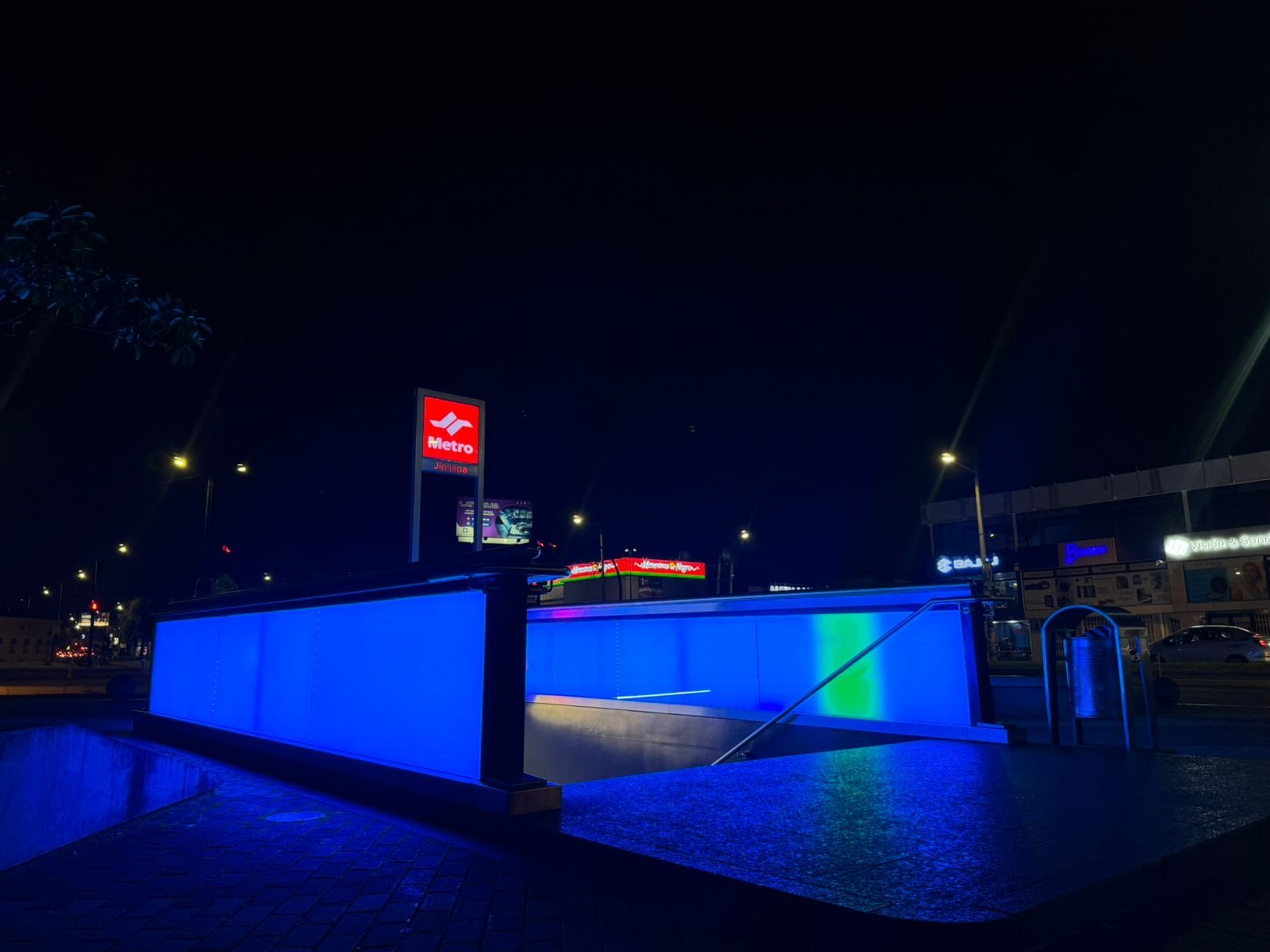 A metro entrance lit up in blue