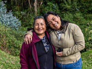 Une Equatorienne de 67 ans et une Vénézuélienne de 39 ans s'embrassent et célèbrent leur amitié au bord d'une rivière.