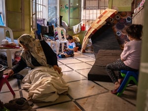 Une femme âgée et deux jeunes enfants dans une salle de classe