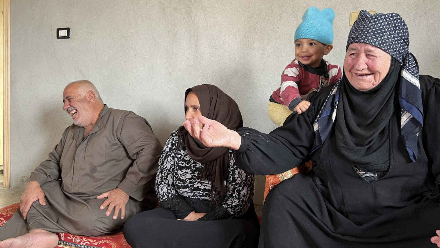Badriyah, together with son Wael and daughter- in- law are sitting in a room which was previously a warehouse. © UNHCR/Vivian Tou'meh