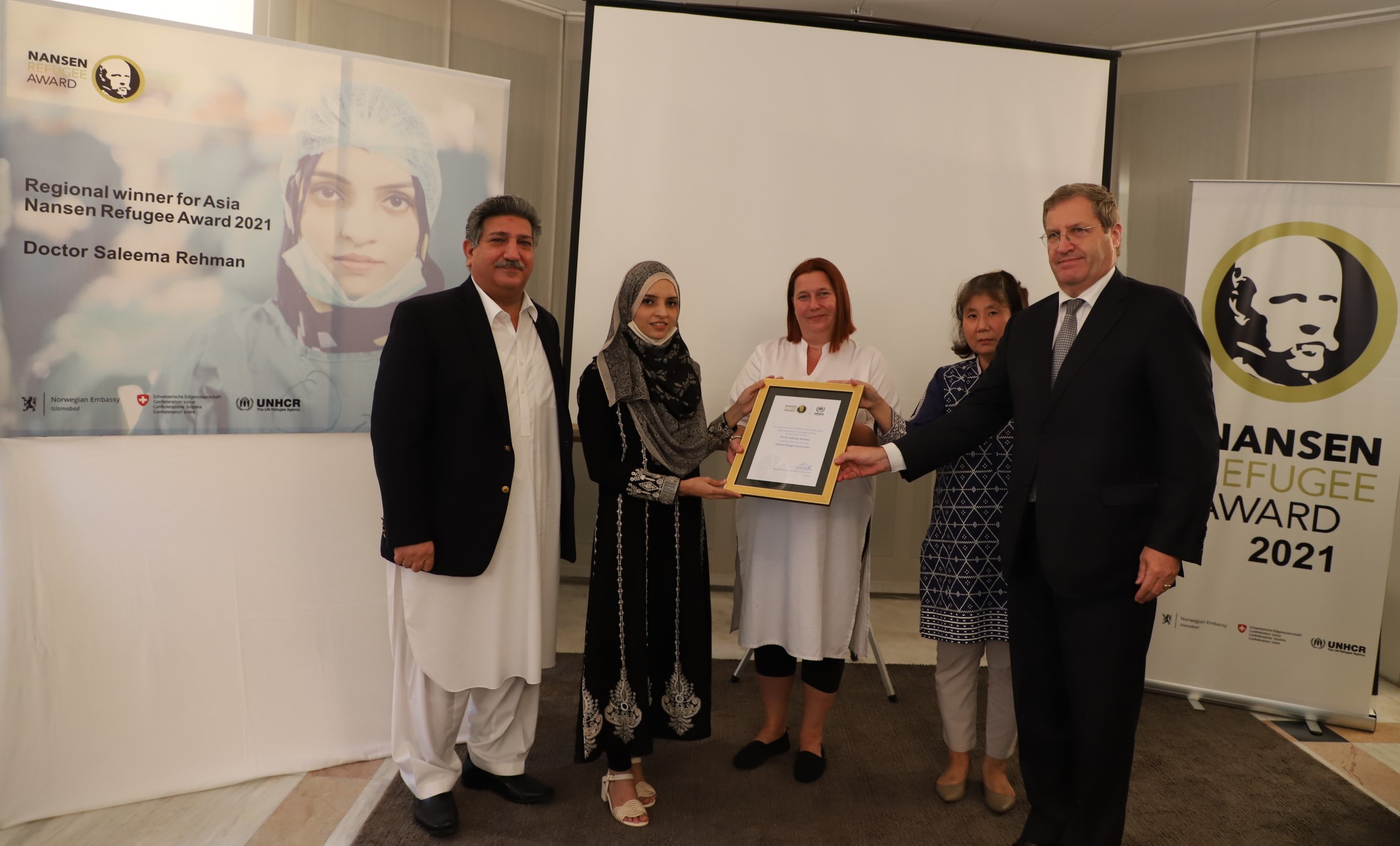 The Ambassador of Switzerland, Bénédict de Cerjat, the UNHCR Representative, Noriko Yoshida, the Chargée d’affaires of Norway, Elin Kylvåg, and the Chief Commissioner for Afghan Refugees, Saleem Khan, presenting an award certificate to the regional winner for Asia of the Nansen Refugee Award, Dr. Saleema Rehman, at the event in Islamabad. © UNHCR/Asif Shahzad