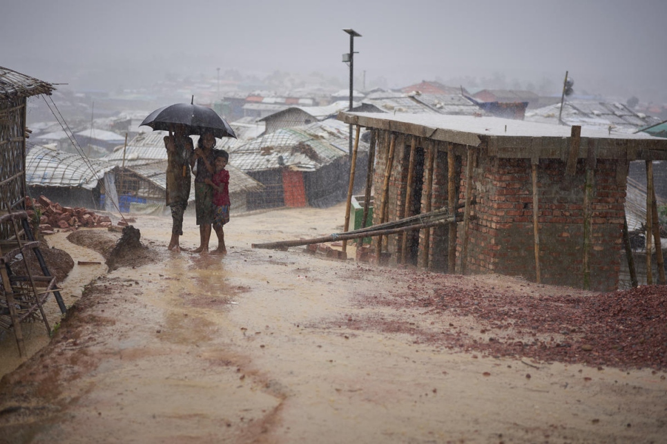 Bangladesh. Rohingya refugees walk through a heavy monsoon downpour