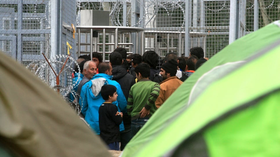 Afghan refugees wait to enter the transit zone at the Röszke border crossing between Serbia and Hungary.